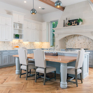 Inspiration for an expansive traditional l-shaped kitchen/diner in Houston with multi-coloured splashback, mosaic tiled splashback, light hardwood flooring, an island, a submerged sink, stainless steel appliances, beige floors, raised-panel cabinets, grey cabinets, granite worktops and grey worktops.