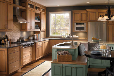 This is an example of a large traditional kitchen in Denver with raised-panel cabinets, stainless steel appliances, medium hardwood flooring and an island.