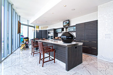 Large transitional single-wall marble floor and white floor enclosed kitchen photo in Miami with an undermount sink, flat-panel cabinets, black cabinets, marble countertops, gray backsplash, stone slab backsplash and an island