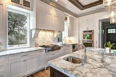 Immagine di una grande cucina chic chiusa con lavello sottopiano, ante in stile shaker, ante bianche, top in marmo, paraspruzzi grigio, elettrodomestici in acciaio inossidabile e parquet chiaro