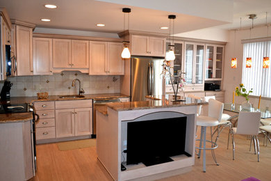 Exempel på ett klassiskt kök, med en undermonterad diskho, skåp i shakerstil, skåp i mellenmörkt trä, granitbänkskiva, beige stänkskydd, stänkskydd i stenkakel, rostfria vitvaror, ljust trägolv och en köksö