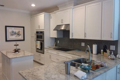 Mid-sized transitional single-wall ceramic tile eat-in kitchen photo in Jacksonville with a double-bowl sink, glass-front cabinets, white cabinets, granite countertops, gray backsplash, subway tile backsplash, stainless steel appliances and an island