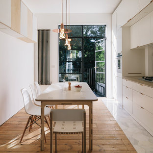 Design ideas for a scandinavian single-wall kitchen/diner in London with flat-panel cabinets, white cabinets, wood worktops and medium hardwood flooring.