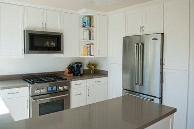 Moderne Küche mit Schrankfronten im Shaker-Stil, weißen Schränken, Quarzwerkstein-Arbeitsplatte, Küchengeräten aus Edelstahl und Halbinsel in San Luis Obispo