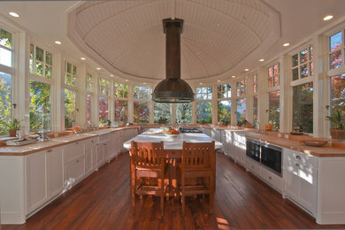 Example of an arts and crafts u-shaped enclosed kitchen design in San Francisco with a farmhouse sink, recessed-panel cabinets, white cabinets, marble countertops and paneled appliances