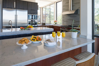 This is an example of a large contemporary u-shaped kitchen/diner in San Francisco with a submerged sink, flat-panel cabinets, medium wood cabinets, engineered stone countertops, grey splashback, porcelain splashback, stainless steel appliances, porcelain flooring and an island.