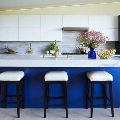 Inspiration for a contemporary galley light wood floor and beige floor kitchen remodel in San Francisco with an undermount sink, shaker cabinets, blue cabinets, gray backsplash, stainless steel appliances, an island and white countertops