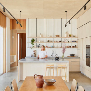 Design ideas for a mid-sized contemporary l-shaped open plan kitchen in Perth with concrete benchtops, concrete floors, with island, grey floor, an undermount sink, flat-panel cabinets, light wood cabinets, panelled appliances and grey benchtop.