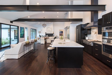 Example of a large minimalist galley dark wood floor and brown floor open concept kitchen design in Los Angeles with an island, shaker cabinets, dark wood cabinets, marble countertops, white backsplash, marble backsplash, stainless steel appliances and an undermount sink