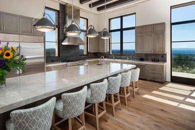 Example of a large trendy light wood floor open concept kitchen design in Los Angeles with an undermount sink, shaker cabinets, medium tone wood cabinets, quartzite countertops, multicolored backsplash, stone tile backsplash, stainless steel appliances and a peninsula