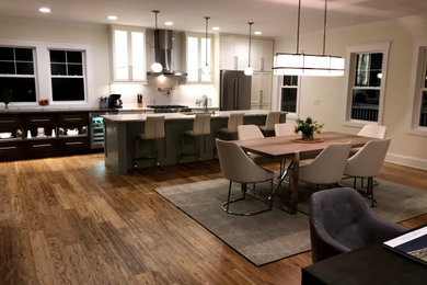 Example of a huge single-wall bamboo floor and brown floor kitchen design in Other with an island, an undermount sink, shaker cabinets, white cabinets, quartz countertops, white backsplash, quartz backsplash, stainless steel appliances and white countertops