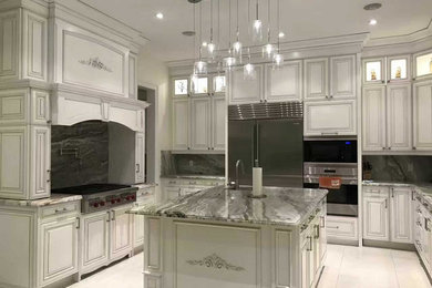 Example of a minimalist galley ceramic tile kitchen design in Toronto with an undermount sink, beaded inset cabinets, gray cabinets, marble countertops, gray backsplash, stone slab backsplash, stainless steel appliances and an island