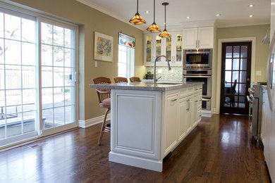 Eat-in kitchen - mid-sized transitional l-shaped medium tone wood floor eat-in kitchen idea in Toronto with an undermount sink, white cabinets, quartz countertops, gray backsplash, porcelain backsplash, stainless steel appliances, an island and raised-panel cabinets