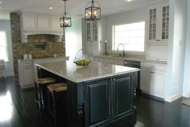 Foto di una cucina chic di medie dimensioni con lavello a doppia vasca, ante con riquadro incassato, ante bianche, top in granito, elettrodomestici in acciaio inossidabile e parquet scuro