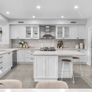 Large transitional l-shaped eat-in kitchen in Brisbane with an undermount sink, shaker cabinets, white cabinets, grey splashback, stainless steel appliances, with island, grey floor and grey benchtop.