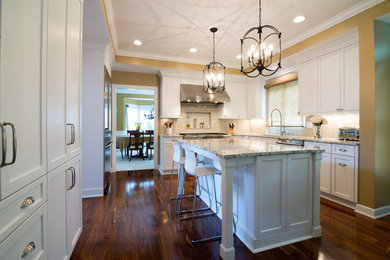 Example of a large transitional u-shaped dark wood floor kitchen design in Other with granite countertops, porcelain backsplash, stainless steel appliances, an undermount sink, shaker cabinets, white cabinets, gray backsplash and an island
