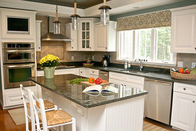 Large beach style l-shaped medium tone wood floor eat-in kitchen photo in Boston with a drop-in sink, recessed-panel cabinets, white cabinets, granite countertops, multicolored backsplash, stone tile backsplash, stainless steel appliances and an island