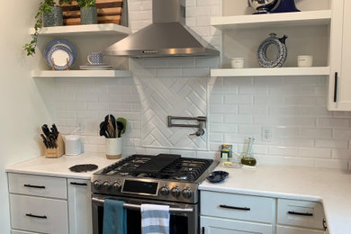 Enclosed kitchen - mid-sized transitional l-shaped medium tone wood floor and brown floor enclosed kitchen idea in Boston with an undermount sink, shaker cabinets, white cabinets, quartz countertops, white backsplash, subway tile backsplash, stainless steel appliances, an island and white countertops