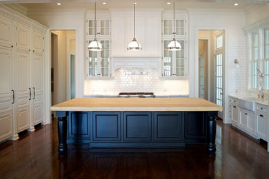 Eat-in kitchen - large transitional u-shaped medium tone wood floor eat-in kitchen idea in Houston with a farmhouse sink, flat-panel cabinets, white cabinets, marble countertops, white backsplash and paneled appliances