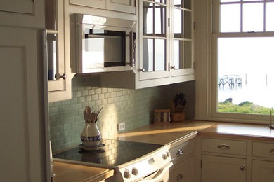 ボストンにあるビーチスタイルのおしゃれなキッチン (インセット扉のキャビネット、白いキャビネット、木材カウンター、セラミックタイルのキッチンパネル、シルバーの調理設備) の写真