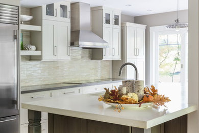Example of a large transitional single-wall light wood floor open concept kitchen design in Boston with an undermount sink, recessed-panel cabinets, gray cabinets, concrete countertops, beige backsplash, ceramic backsplash, stainless steel appliances and an island