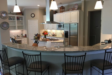 Inspiration for a mid-sized transitional kitchen remodel in Houston with white cabinets and an island