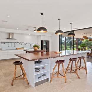 Contemporary kitchen in Perth with flat-panel cabinets, white cabinets, white splashback, glass sheet splashback, stainless steel appliances, beige floor, white benchtop and multiple islands.