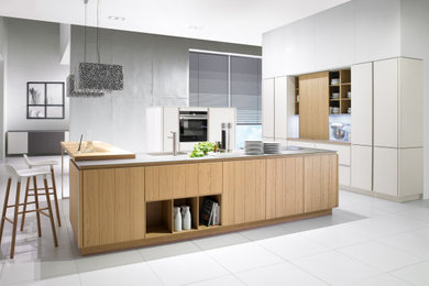 Inspiration for a medium sized modern u-shaped open plan kitchen in Manchester with an integrated sink, flat-panel cabinets, white cabinets, laminate countertops, porcelain flooring and multiple islands.