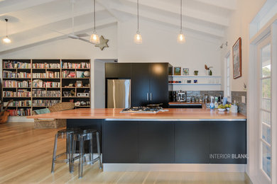 Idee per una cucina minimal di medie dimensioni con ante lisce, ante nere e penisola