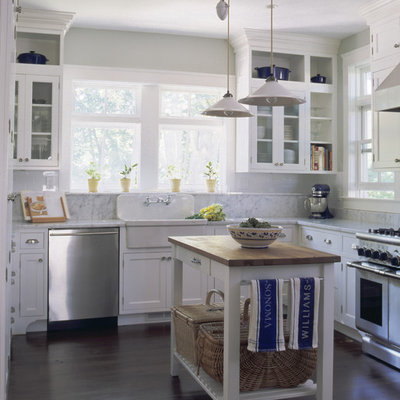 Inspiration for a timeless kitchen remodel in New York with glass-front cabinets, stainless steel appliances and a farmhouse sink