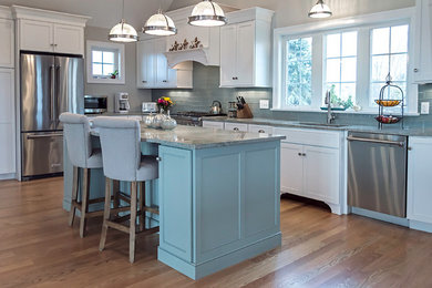 Example of a large beach style l-shaped medium tone wood floor eat-in kitchen design in Providence with an undermount sink, shaker cabinets, blue cabinets, granite countertops, blue backsplash, glass tile backsplash, stainless steel appliances and an island