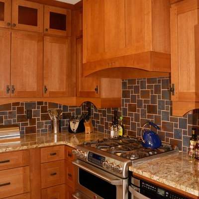 Large arts and crafts l-shaped porcelain tile eat-in kitchen photo in Minneapolis with an undermount sink, shaker cabinets, medium tone wood cabinets, granite countertops, brown backsplash, ceramic backsplash and stainless steel appliances