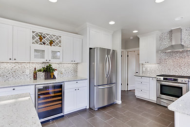 Mid-sized minimalist u-shaped eat-in kitchen photo in Los Angeles with recessed-panel cabinets, white cabinets and an island