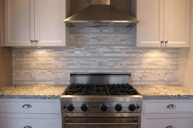 Mittelgroße Moderne Küche mit Schrankfronten im Shaker-Stil, weißen Schränken, Granit-Arbeitsplatte, Küchenrückwand in Grau, Rückwand aus Stäbchenfliesen und Küchengeräten aus Edelstahl in Vancouver