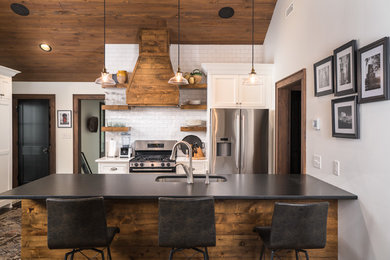 Inspiration for a rustic u-shaped multicolored floor kitchen remodel in Charlotte with an undermount sink, recessed-panel cabinets, white cabinets, white backsplash, subway tile backsplash, a peninsula and black countertops