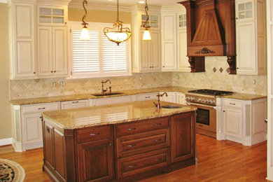 Inspiration for a timeless medium tone wood floor kitchen remodel in Louisville with white cabinets, an island, an undermount sink, granite countertops, beige backsplash and stainless steel appliances