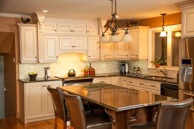 Example of a mid-sized classic l-shaped light wood floor and beige floor eat-in kitchen design in Other with a double-bowl sink, raised-panel cabinets, white cabinets, granite countertops, beige backsplash, porcelain backsplash, stainless steel appliances and an island