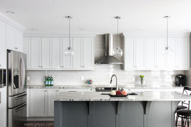 Inspiration for a mid-sized transitional l-shaped medium tone wood floor eat-in kitchen remodel in Calgary with a drop-in sink, shaker cabinets, gray cabinets, granite countertops, gray backsplash, ceramic backsplash, stainless steel appliances and an island