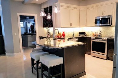 Inspiration for a mid-sized contemporary u-shaped beige floor eat-in kitchen remodel in Calgary with an undermount sink, shaker cabinets, white cabinets, granite countertops, marble backsplash, stainless steel appliances, a peninsula and white backsplash
