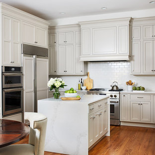 Foto di una cucina classica di medie dimensioni con ante beige, paraspruzzi bianco, paraspruzzi con piastrelle diamantate, pavimento in legno massello medio, isola, top bianco, lavello sottopiano, ante in stile shaker, elettrodomestici da incasso e pavimento arancione