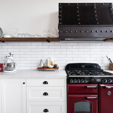 Industrial Kitchen with red oven and pressed metal rangehood