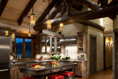This is an example of a medium sized rustic l-shaped open plan kitchen in Denver with a belfast sink, shaker cabinets, dark wood cabinets, stainless steel appliances, medium hardwood flooring, an island and granite worktops.