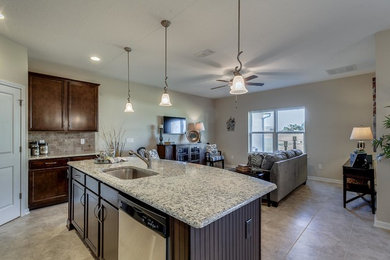 Example of a mid-sized classic l-shaped ceramic tile eat-in kitchen design in Jacksonville with an undermount sink, recessed-panel cabinets, dark wood cabinets, granite countertops, gray backsplash, stone tile backsplash, stainless steel appliances and an island