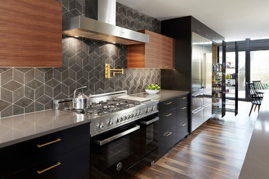 Mid-century modern kitchen photo in Dallas with solid surface countertops, an island and gray countertops