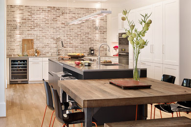 Inspiration for a large contemporary l-shaped light wood floor and beige floor eat-in kitchen remodel in Atlanta with shaker cabinets, an island, a single-bowl sink, white cabinets, stainless steel appliances, quartz countertops, multicolored backsplash, brick backsplash and gray countertops