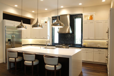 Example of a large eclectic eat-in kitchen design in Tampa with recessed-panel cabinets, white cabinets, quartz countertops, white backsplash, ceramic backsplash, stainless steel appliances and an island