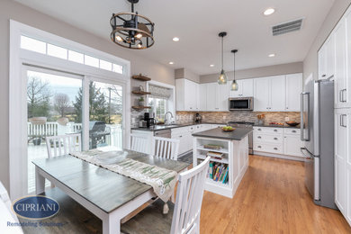 Eat-in kitchen - large transitional l-shaped eat-in kitchen idea in Philadelphia with shaker cabinets, quartz countertops, multicolored backsplash, porcelain backsplash, stainless steel appliances, an island and brown countertops