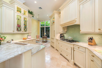 Enclosed kitchen - large transitional u-shaped limestone floor enclosed kitchen idea in Miami with an undermount sink, raised-panel cabinets, light wood cabinets, granite countertops, green backsplash, glass tile backsplash, paneled appliances and no island