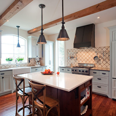 Tuscan l-shaped kitchen photo in Vancouver with a farmhouse sink, shaker cabinets, gray cabinets, beige backsplash and paneled appliances