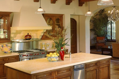 Example of a classic l-shaped eat-in kitchen design in Santa Barbara with beaded inset cabinets, medium tone wood cabinets and an island